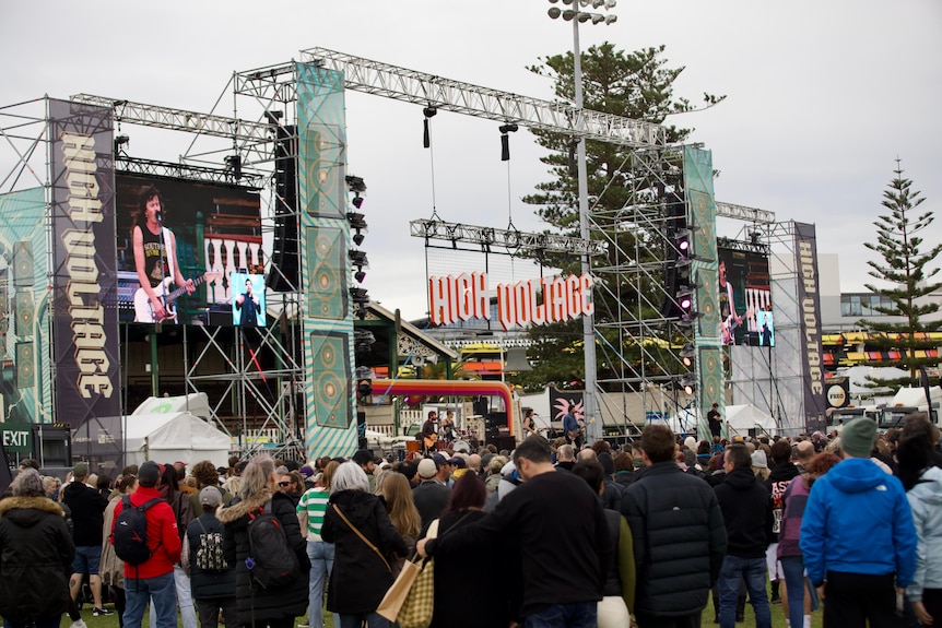 People watch on as a band plays on stage.