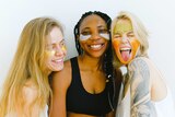 Three women with face masks laughing in a story about a bare minimum skincare routine for those on a budget.
