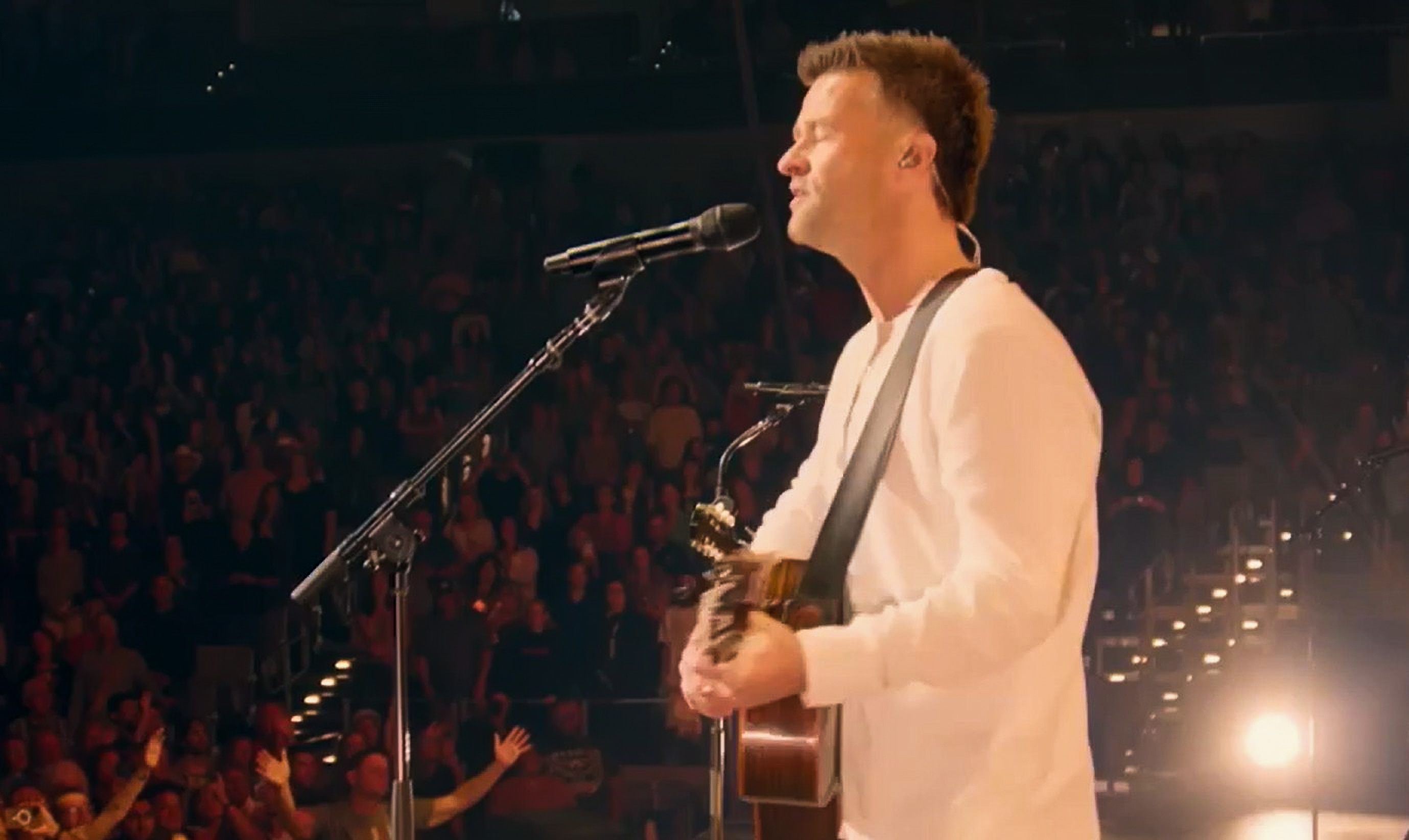 Um homem no palco com uma guitarra.