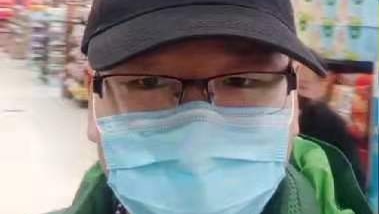 A man in a supermarket wearing a facemask.