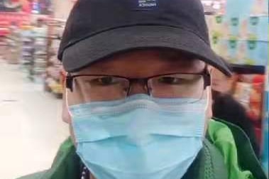A man in a supermarket wearing a facemask.