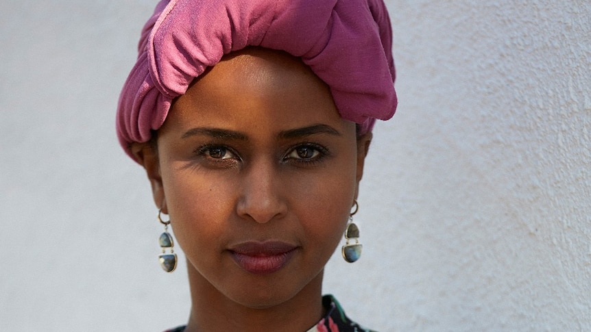 A woman wearing a pink headscarf.