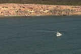 A boat in water near rocks