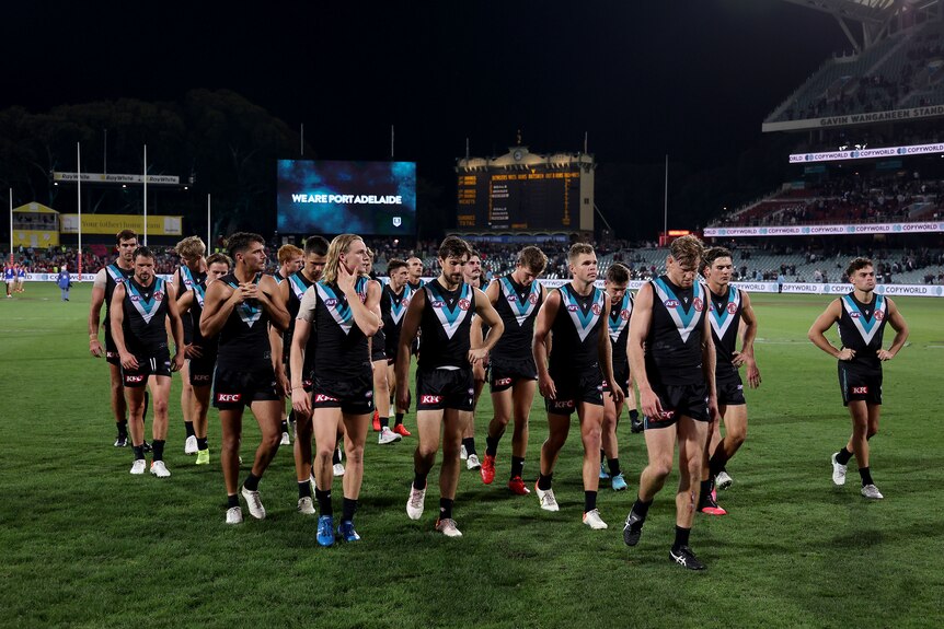 Sad Port Adelaide players leave the Adelaide Oval field together