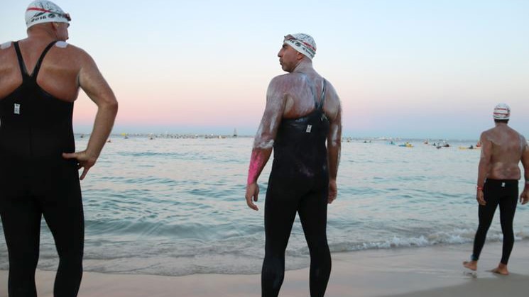 David Hewitt stands on Cottesloe beach with two mates, preparing to swim to Rottnest.