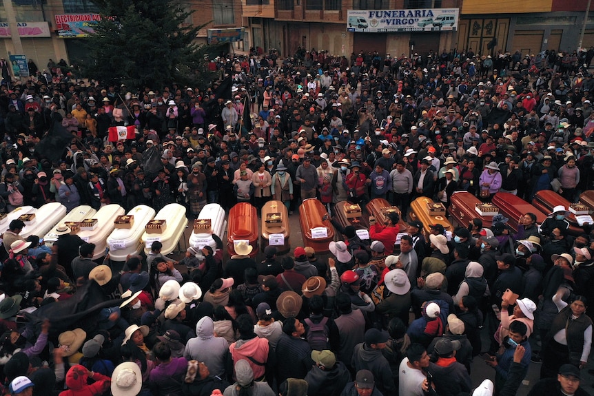 Residents surround coffins during a vigil in Juliaca in Peru.