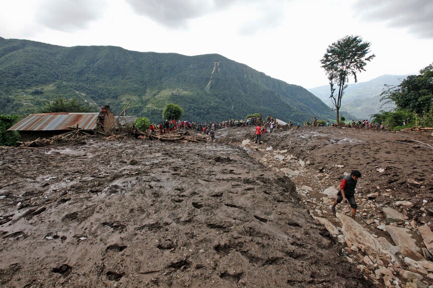 I soccorritori nepalesi cercano i corpi delle vittime sotto le macerie dopo una frana nel villaggio di Lumli.