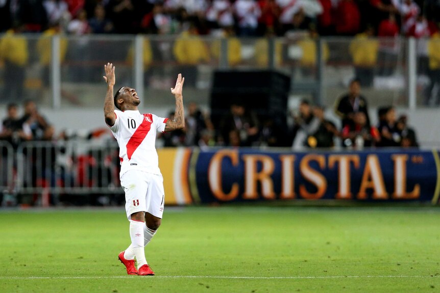 Jefferson Farfan raises his arms and looks to the sky as he celebrates a goal for Peru against New Zealand.