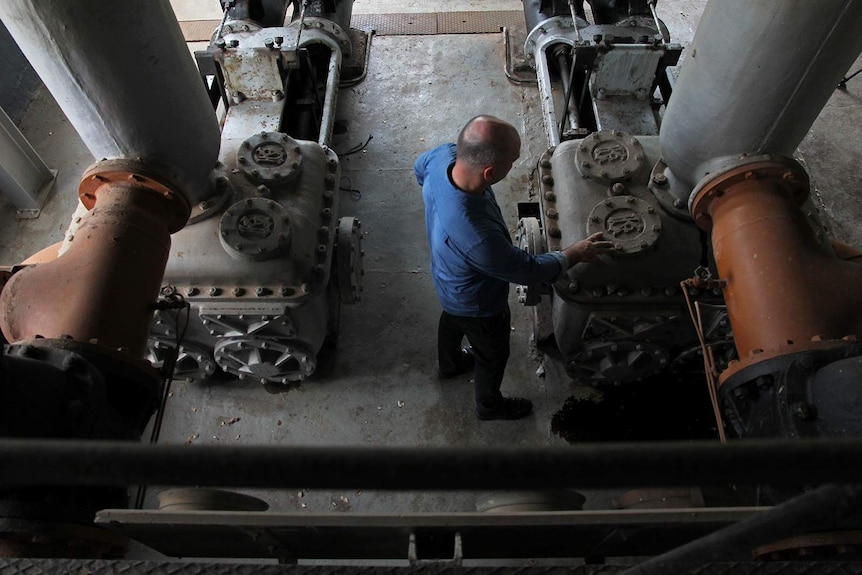 A bird's eye photo of Michael Wells inspecting old engineering equipment.