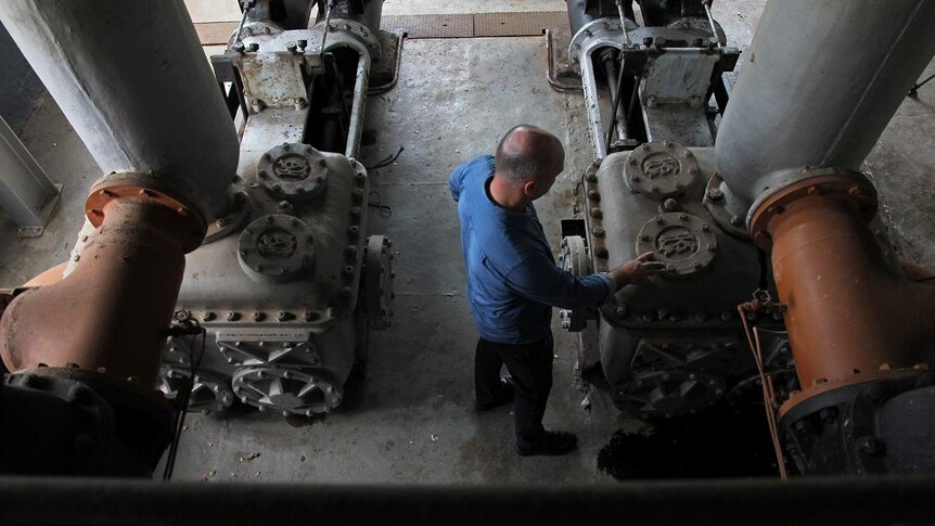 A bird's eye photo of Michael Wells inspecting old engineering equipment.