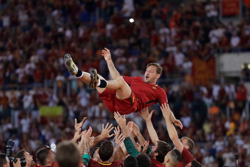 Francesco Totti is thrown in the air by Roma team-mates after his last game