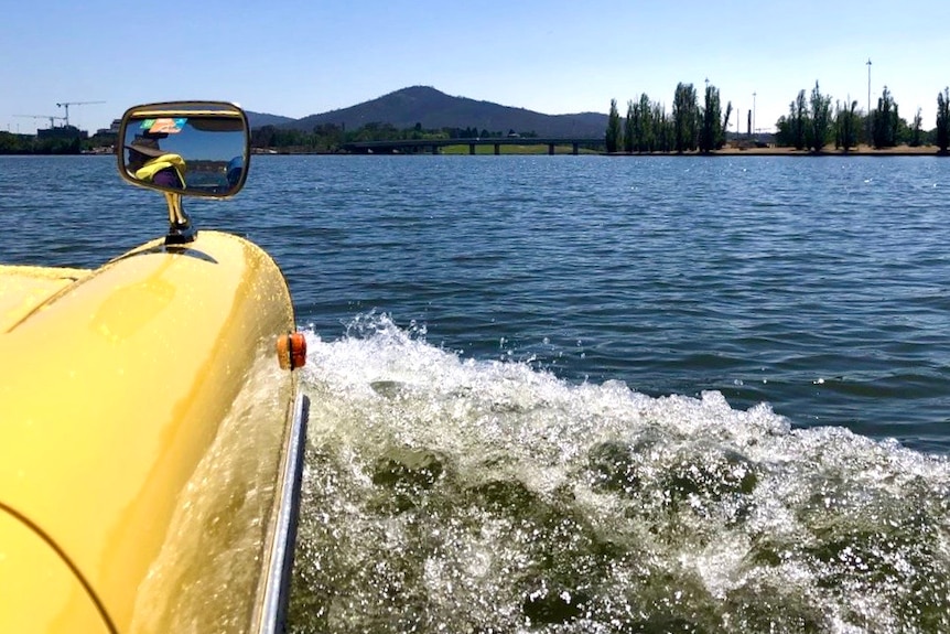 A wake of water is created as a car moves through a lake.