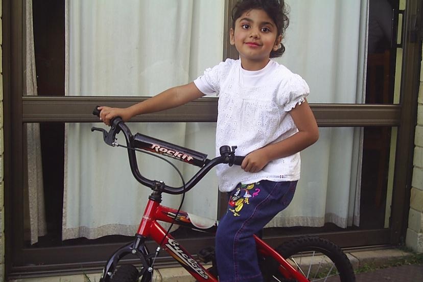 A young Iranian girl poses with her bike. 