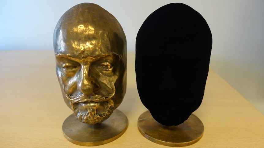 One ordinary bronze cast and another that has been coated with Vantablack that is completely black