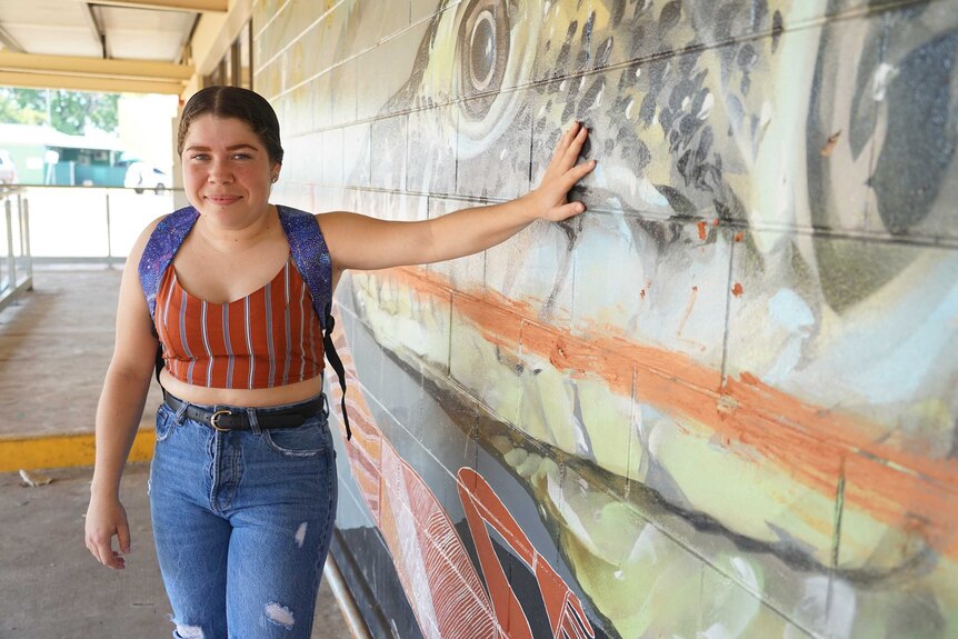 Miannah Reid is wearing jeans and a shirt with a backpack. She is in Jabiru's town centre.