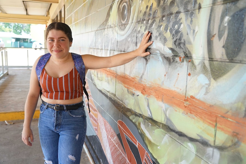 Miannah Reid is wearing jeans and a shirt with a backpack. She is in Jabiru's town centre.