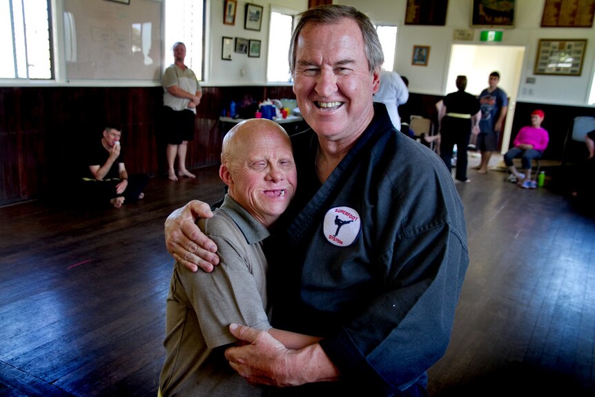 Taekwondo teacher Ian Fauth hugs Bill who is one of his students with a disability.
