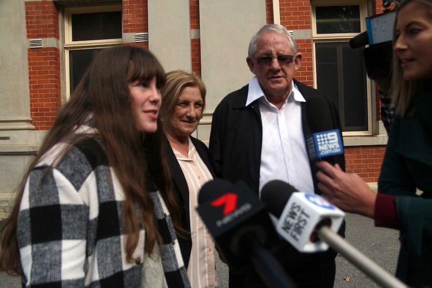 Heidi Austic with her parents outside of court.