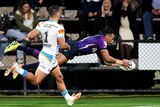 Melbourne Storm winger Josh Addo-Carr dives through the air for a try against the Gold Coast Titans.