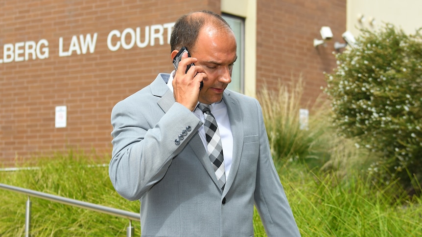 A man wearing a suit on a mobile phone.