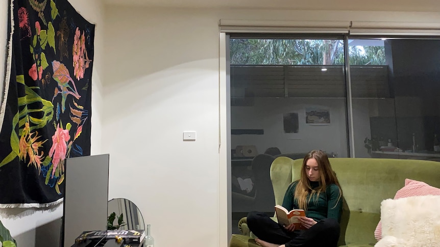 a young woman on a couch reading a book