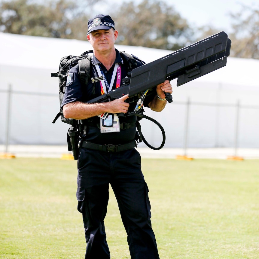 Un policier avec un sac à dos et un gros fusil drone