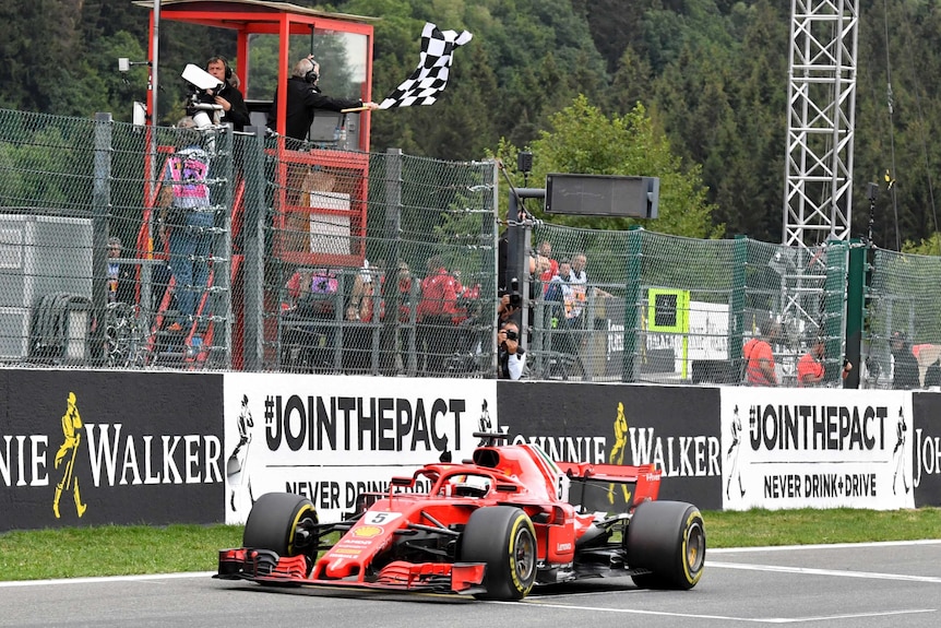 Ferrari driver Sebastian Vettel of Germany receives the chequered flag.