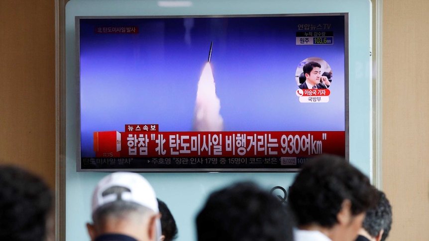 People watch a TV broadcast of a news report on North Korea's ballistic missile test