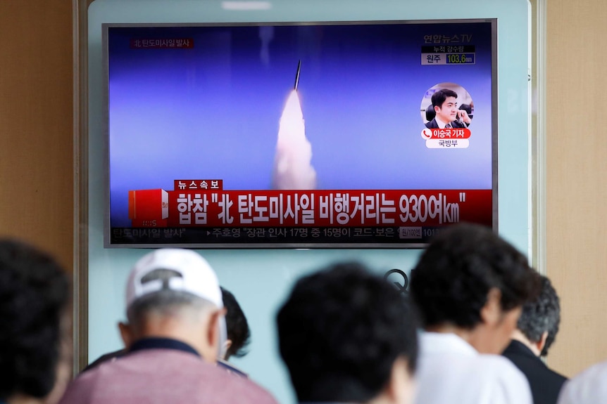 People watch a TV broadcast of a news report on North Korea's ballistic missile test