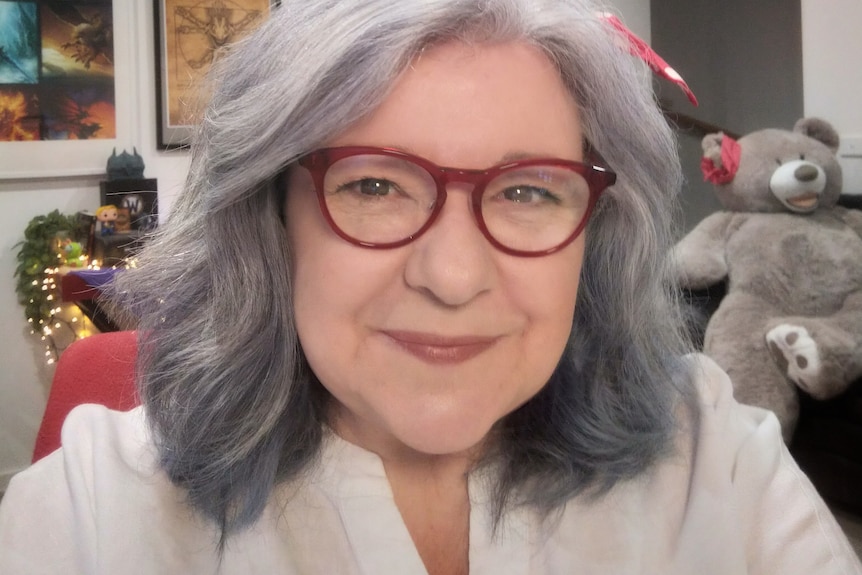 A woman with grey hair and glasses.