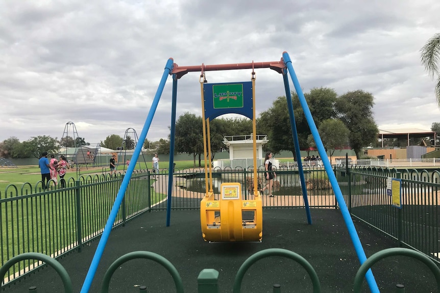 A Liberty swing in an isolated fenced-in enclosure at a playground.