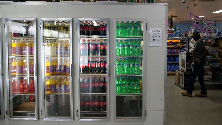 The cool room within the local store is filled with bottles of soft drink