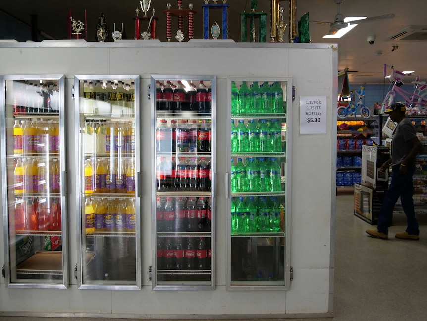 The cool room within the local store is filled with bottles of soft drink