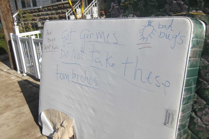 Writing on a thrown out mattress says 'got germs, do not take these'