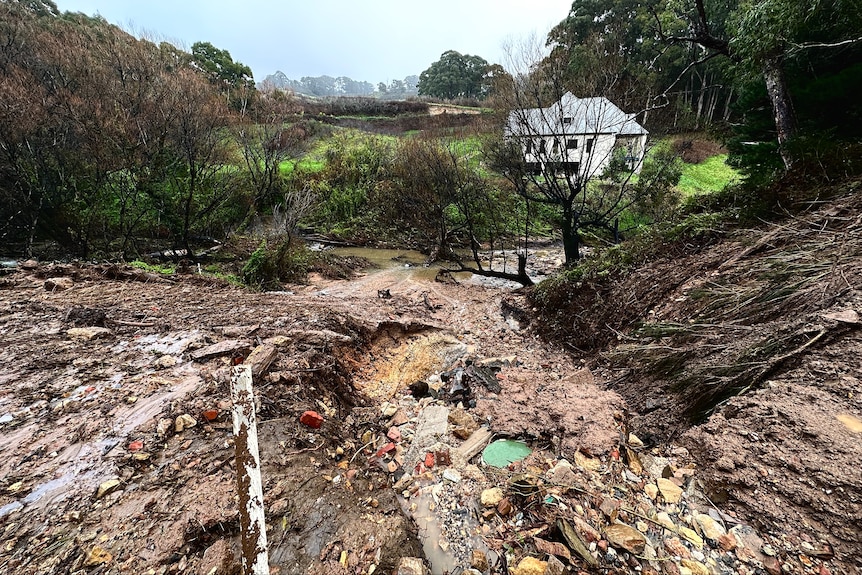 Spillage from a dam at Basket Range leaving debris, rocks and mud everywhere