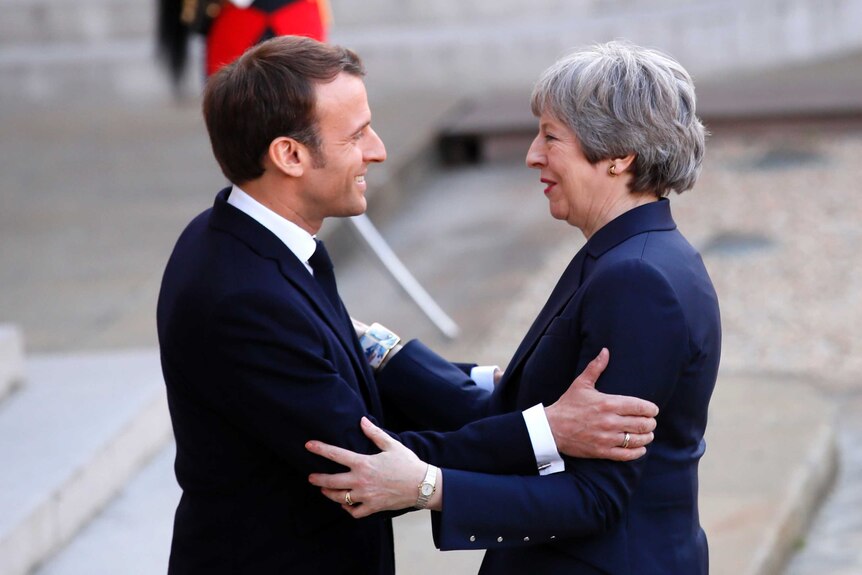 A close-up photo shows President Emmanuel Macron greeting British Prime Minister Theresa May on the steps of the Elysee Palace.