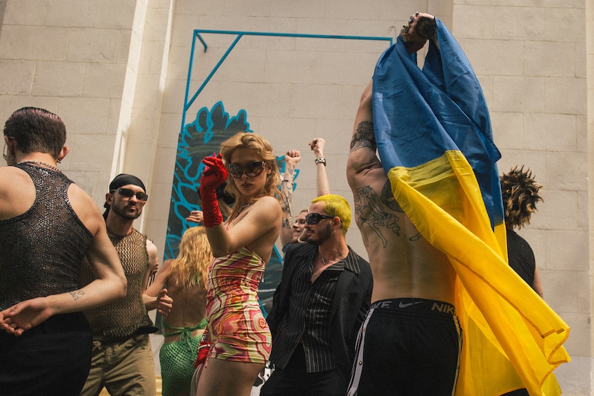 A group of people dance outside. 