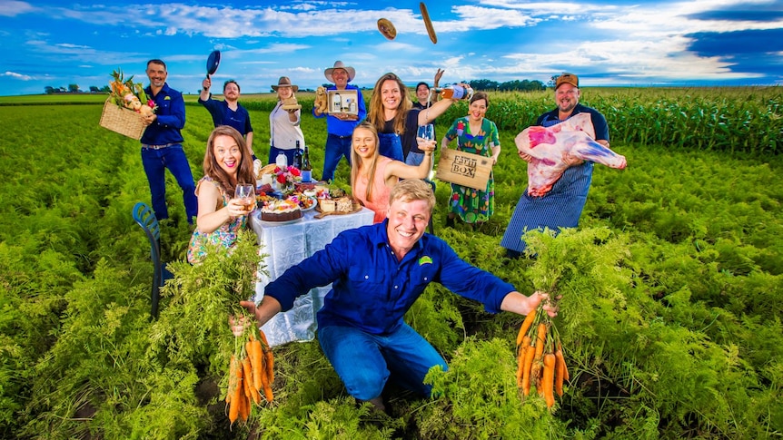 Group of people in a paddock holding fresh produce