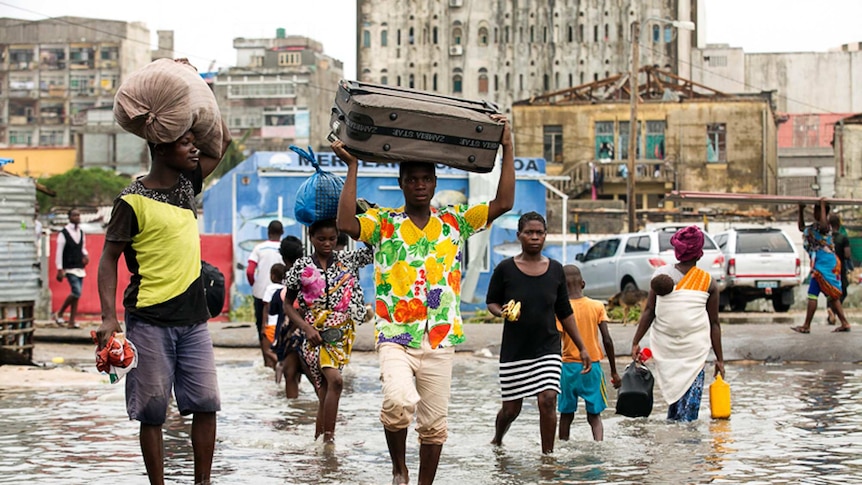 Residents of Beira walk through flood waters