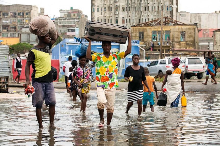 Residents of Beira walk through flood waters