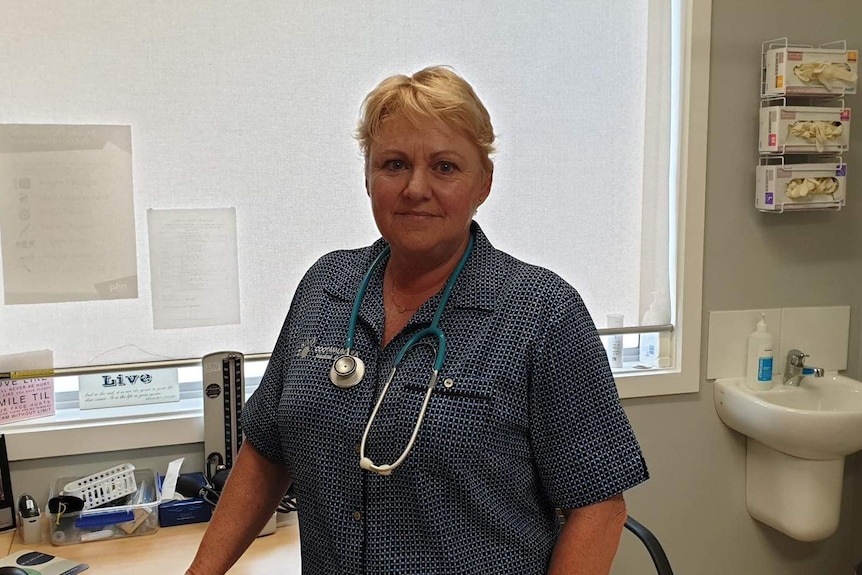 Woman in blue shirt with stethoscope around her neck