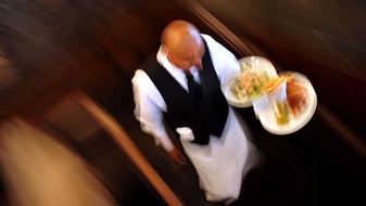 Waiter carries dishes (Gabriel Bouys, file photo: AFP)