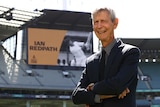 A man picture in front of a video screen that reads "Ian Redpath"