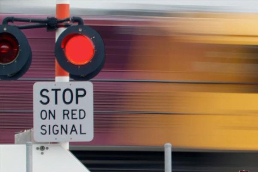 Freight train rushes through a level crossing