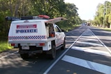 A police forensic crash car blocking one lane of the road, other vehicles in the background