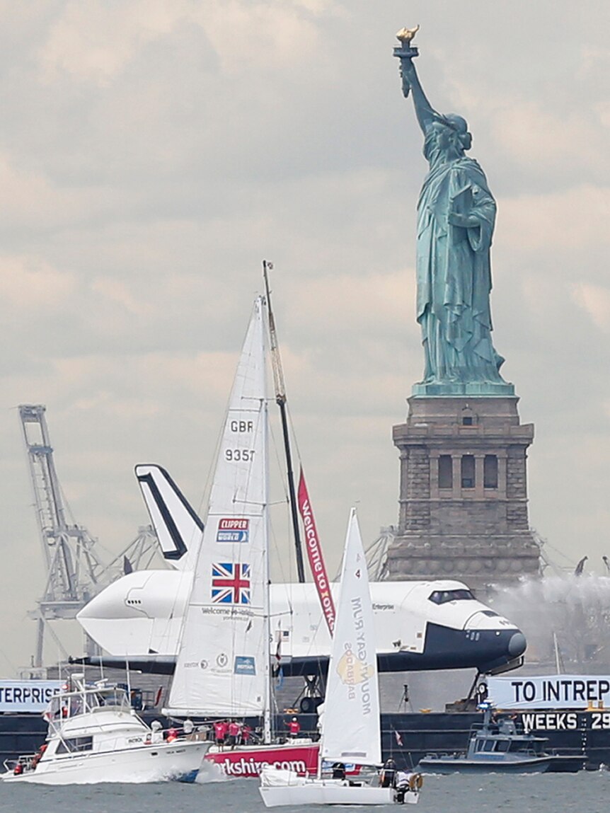 The space shuttle Enterprise passes the Statue of Liberty as it rides on a barge in New York's harbour.