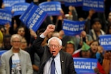 Bernie Sanders pumps fist with supporters in background