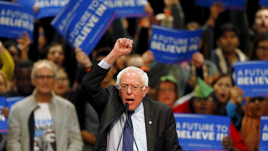 Bernie Sanders pumps fist with supporters in background