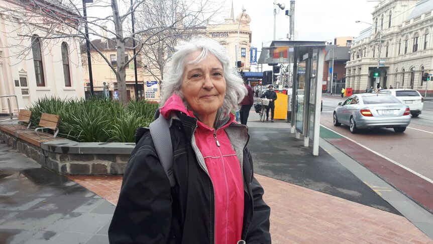 Connie Nikolovski stands smiling at the camera from the footpath on Sydney Road in Brunswick