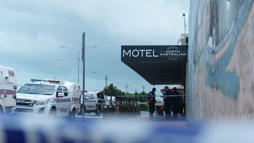 Police cars and tape outside a sign that reads  Motel North Australia
